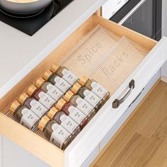 an open drawer with spices and seasonings in it on a counter top next to a stove