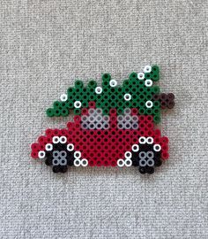 a red car with a christmas tree on the roof is made out of perler beads