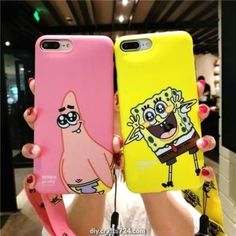 two people holding up cell phones with cartoon characters on them, one is pink and the other is yellow