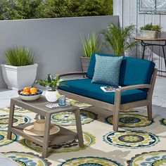 an outdoor patio with blue furniture and potted plants