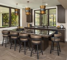 a large kitchen with an island and bar stools