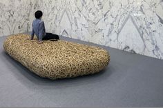 a man sitting on top of a bean bag chair in front of a marble wall