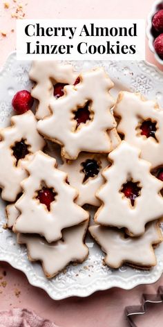 cherry almond linzer cookies on a white plate with raspberries in the background