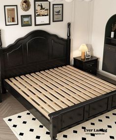 a black bed frame with wooden slats in a bedroom