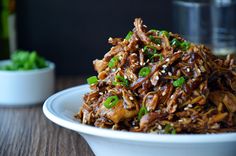 a white bowl filled with food on top of a wooden table