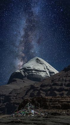 the night sky is filled with stars above a mountain