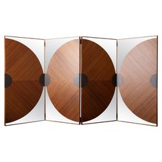 an image of three wooden discs in a room divider with mirrors on each side