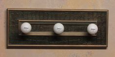 three golf balls are mounted to the wall