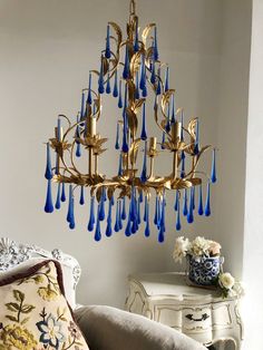 a chandelier hanging from the ceiling in a living room with blue glass drops