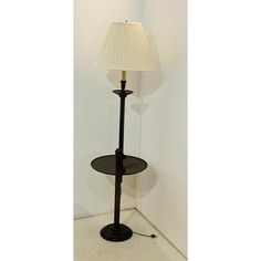 a lamp that is on top of a table next to a wall with a shadow