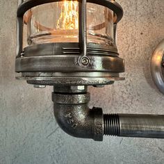 a close up of a light on a wall with a pipe attached to the side