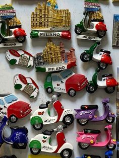 there are many toy cars and scooters on the wall in front of each other