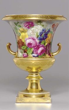 a gold vase with flowers painted on it