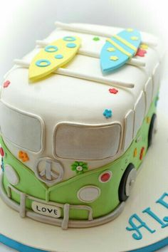 the cake is decorated like a bus and has surfboards on it's roof