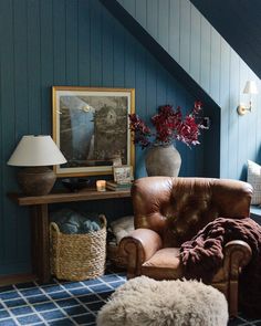 a living room with blue walls and leather furniture in the corner, including a brown chair