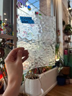 a person holding up a piece of ice in front of a window with the words stay clear on it