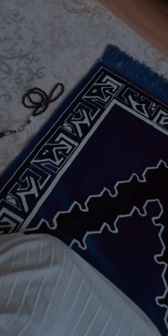 a blue and white rug laying on top of a wooden floor next to a pair of scissors