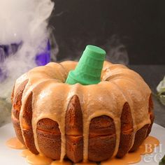 a bundt cake with icing and a green top sitting on a white plate