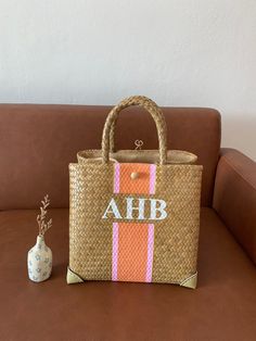 a bag sitting on top of a couch next to a vase