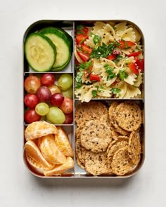 a bento box filled with different types of food including crackers, fruit and veggies