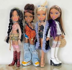 four dolls are standing next to each other