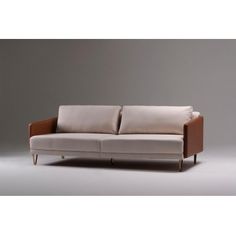 an image of a couch that is in the middle of a room with grey walls