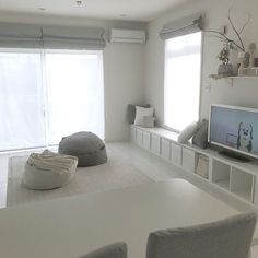 a living room filled with furniture and a flat screen tv sitting on top of a white table