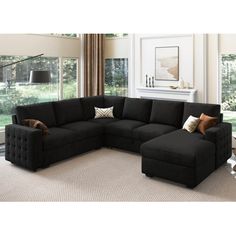 a living room with a black sectional couch and pillows on the bottom right hand corner