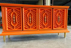 an orange sideboard with ornate carvings on it