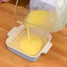 someone pours yellow liquid into a container