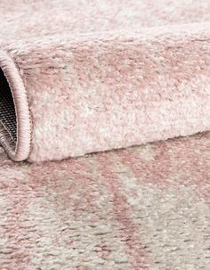 a close up view of a pink and white rug