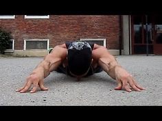 the man is doing push ups on his hands and knees in front of a brick building