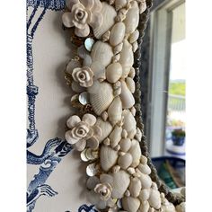 shells and seashells hang on the wall in front of a blue and white background