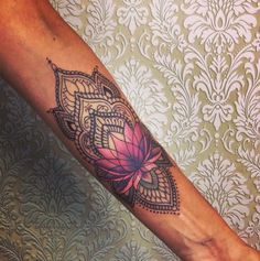 a woman's leg with a tattoo on it that has a flower in the center