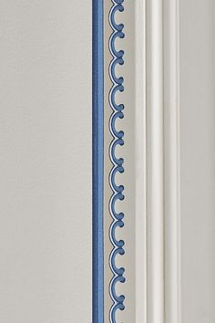 the corner of a door with blue trim on it and a white wall in the background