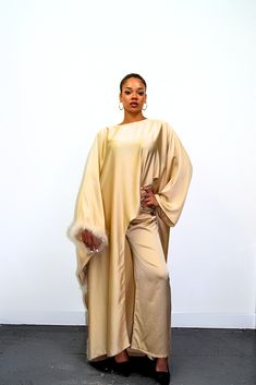 Embrace timeless elegance with our exquisite Satin Abaya Co-Ord Set. This stunning two-piece ensemble features a luxurious, soft-flowing satin fabric that drapes beautifully and flatters your figure. The elegant abaya boasts a modest silhouette, perfect for everyday wear or special occasions. The highlight of this set is the exquisite fur trim. This touch of luxury adds a touch of sophistication and warmth to the design, making it perfect for cooler evenings or formal events. Key Features Luxurious Satin Fabric: Experience the soft, smooth feel of premium satin that flatters your form. Elegant Abaya Silhouette: This modest design offers full coverage while maintaining a stylish and graceful drape. Delicate Fur Trim: Elevate your look with a touch of luxury and warmth. Two-Piece Co-Ord Set: Chic Floor-length Abaya, Cape Abaya For Evening And Eid, Elegant Evening Thobe In Maxi Length, Evening Maxi Sets For Eid, Elegant Floor-length Party Thobe, Evening Solid Color Maxi Length Abaya, Evening Solid Maxi Length Abaya, Evening Maxi Length Solid Abaya, Elegant Cape Dress For Eid