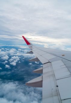 the wing of an airplane flying over clouds