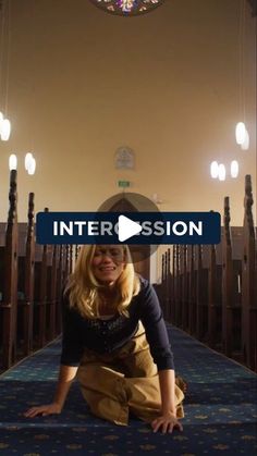 a woman kneeling on the floor in front of a stained glass window with an inter session sign above her head