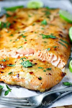 a close up of a fish on a plate with limes