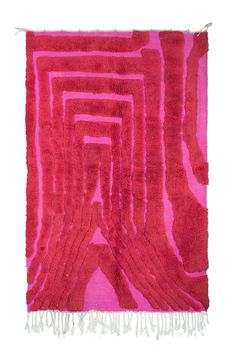 a red and pink rug with fringes on it's edges, in the shape of an interlocked rectangle