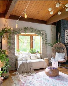 a living room filled with lots of furniture and plants on the wall next to a window