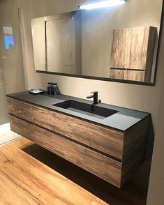 a bathroom with a sink, mirror and wooden counter top in the middle of it