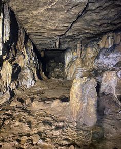 the inside of a cave with large rocks and rock formations on it's sides