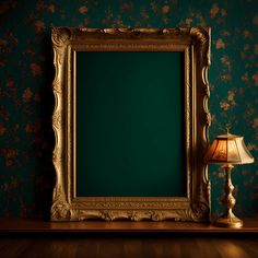 an empty gold frame sitting on top of a wooden table next to a lamp