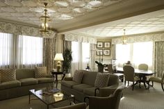 a living room filled with lots of furniture next to a dining room table and chairs