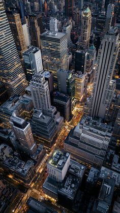 an aerial view of skyscrapers at night in new york city, with lights on