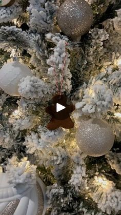 the christmas tree is decorated with white and silver ornaments