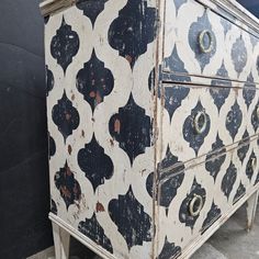 an old dresser with black and white designs on it