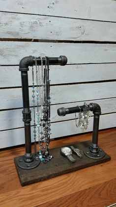 a metal pipe rack with glass beads and other items on it, sitting on top of a wooden table