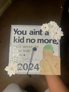 someone is holding up a graduation cap that says you annt a kid no more